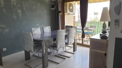 a dining room with a table and chairs and a balcony at Beau T3 70m2 Ajaccio in Ajaccio