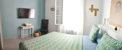 a bedroom with a bed and a television in it at Bel F2 près de la plage in Ajaccio