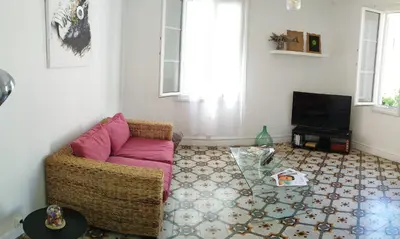 a living room with a couch and a television at Bel F2 près de la plage in Ajaccio