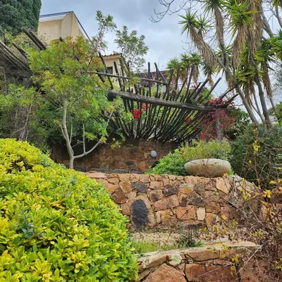 a garden with a stone wall and some plants at Sunrise T2 avec jacuzzi vue mer in Porto-Vecchio