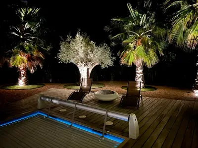 a table and two chairs on a deck with palm trees at le Pied à Terre 2 PORTICCIO in Porticcio