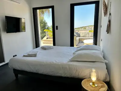 a bedroom with a bed with a view of a patio at le Pied à Terre 2 PORTICCIO in Porticcio