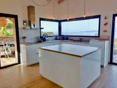 a kitchen with a large island in the middle of it at Villa ARIA et MAQUIS, Villa 4 chambres- Piscine - Plage à pied - vue mer in Pietrosella