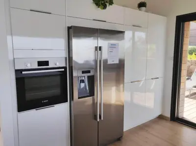 a stainless steel refrigerator in a kitchen with white cabinets at Villa ARIA et MAQUIS, Villa 4 chambres- Piscine - Plage à pied - vue mer in Pietrosella