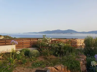 a garden with a wooden fence and flowers at Villa ARIA et MAQUIS, Villa 4 chambres- Piscine - Plage à pied - vue mer in Pietrosella