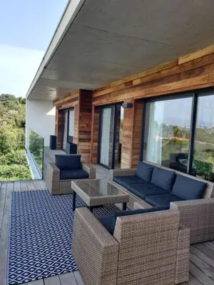 a patio with couches and a table and windows at Villa ARIA et MAQUIS, Villa 4 chambres- Piscine - Plage à pied - vue mer in Pietrosella