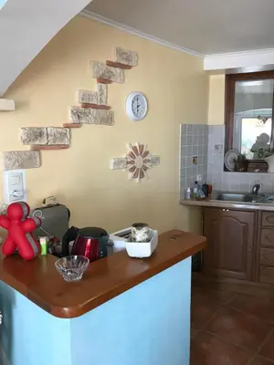 a kitchen with a counter and a clock on the wall at Studio de 39 m2 in Vezzani