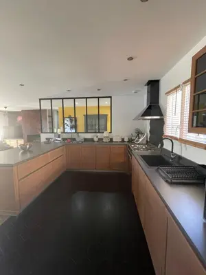 a large kitchen with wooden cabinets and a counter top at Magnifique villa récente entre mer et montagne située entre Ajaccio et Porticcio in Cauro