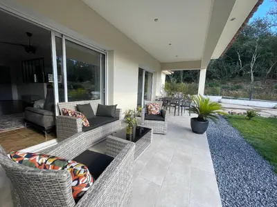 a patio with wicker chairs and a couch at Magnifique villa récente entre mer et montagne située entre Ajaccio et Porticcio in Cauro