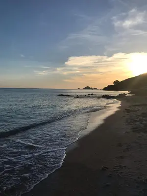 a beach with the sun rising over the ocean at Magnifique villa récente entre mer et montagne située entre Ajaccio et Porticcio in Cauro
