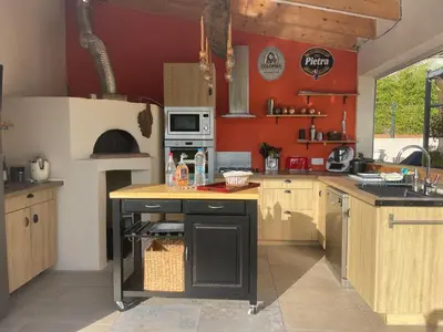 a kitchen with red walls and a counter with a sink at Magnifique villa récente entre mer et montagne située entre Ajaccio et Porticcio in Cauro
