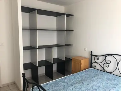 a bedroom with a black book shelf next to a bed at Superbe Appartement Vue Montagne Proximités Grandes Surfaces in Poggi