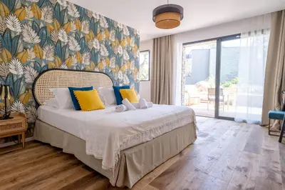a bedroom with a bed with a colorful wall at Villa Renajolo 16 pers piscine chauffée 2 min plage en voiture in Sainte-Lucie de Porto-Vecchio