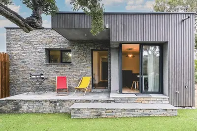 a brick house with two chairs on a patio at Villa Renajolo 16 pers piscine chauffée 2 min plage en voiture in Sainte-Lucie de Porto-Vecchio