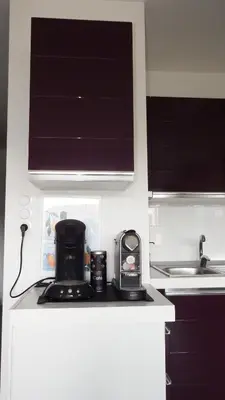 a kitchen with a coffee maker on a counter at Appartement de standing avec piscine et terrasse in Porto-Vecchio