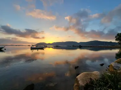 a sunset on a lake with boats in the water at Appartement de standing avec piscine et terrasse in Porto-Vecchio