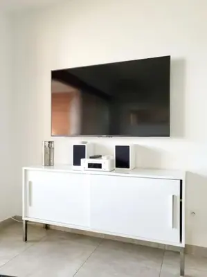 a white cabinet with a television on top of it at Appartement de standing avec piscine et terrasse in Porto-Vecchio