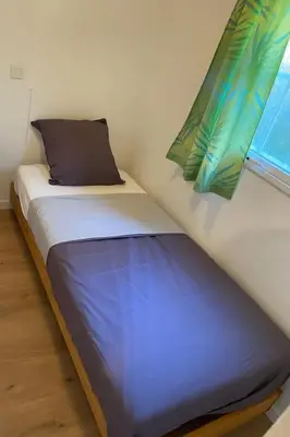 a small bed in a room with a window at Mobilhome à la campagne in Porto-Vecchio