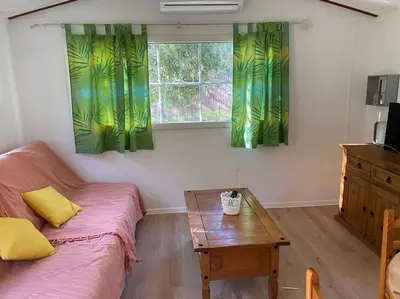 a room with a bed and a table and a window at Mobilhome à la campagne in Porto-Vecchio