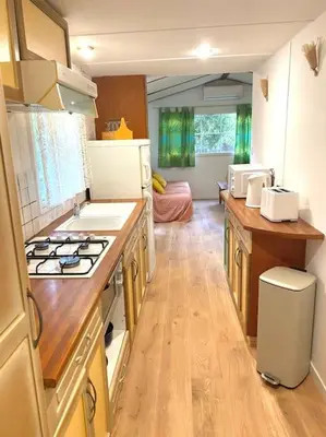 a kitchen with a stove and a counter top at Mobilhome à la campagne in Porto-Vecchio
