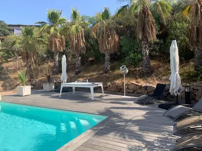 a pool with a table and umbrellas on a deck at Appartement - Maison 