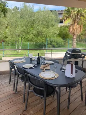 a black table and chairs on a deck at Appartement - Maison 