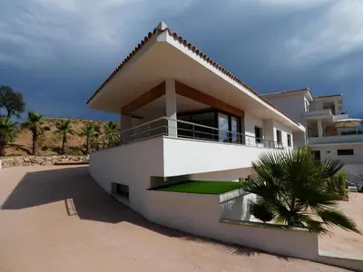 a white house with a palm tree in front of it at Appartement - Maison 