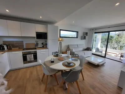 a kitchen and living room with a table and chairs at Domaine de Pacciolello - Porticcio in Porticcio