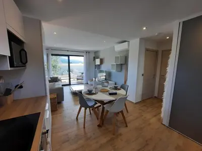 a kitchen and living room with a table and chairs at Domaine de Pacciolello - Porticcio in Porticcio