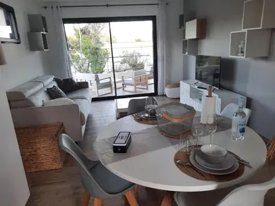 a kitchen and living room with a table and chairs at Domaine de Pacciolello - Porticcio in Porticcio