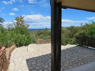 a patio with a view of the ocean at Maison Le Guetali in Sainte-Lucie de Porto-Vecchio