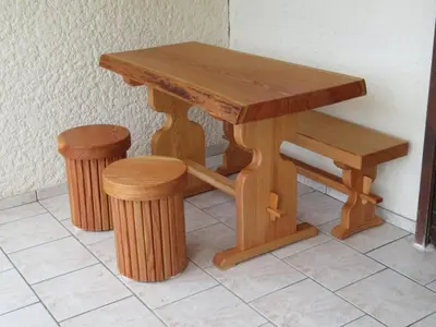 a wooden table with two stools and a bench at Maison Le Guetali in Sainte-Lucie de Porto-Vecchio