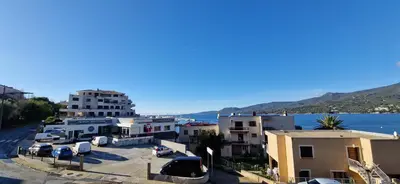 a group of buildings next to a body of water at T2 Fronte Di Mare de standing en bord de mer et du centre du village de Propriano in Propriano