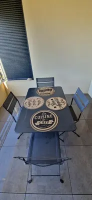 a table with chairs and a table with signs on it at T2 Fronte Di Mare de standing en bord de mer et du centre du village de Propriano in Propriano