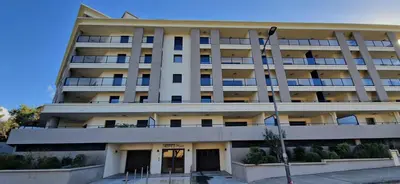 a large white building with a lot of windows at T2 Fronte Di Mare de standing en bord de mer et du centre du village de Propriano in Propriano