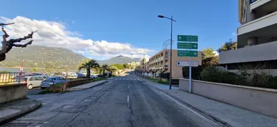 an empty street with buildings and a street sign at T2 Fronte Di Mare de standing en bord de mer et du centre du village de Propriano in Propriano