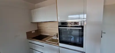a kitchen with white cabinets and a sink and a microwave at T2 Fronte Di Mare de standing en bord de mer et du centre du village de Propriano in Propriano