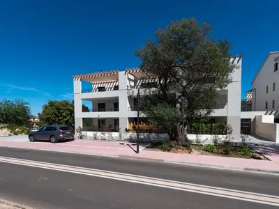 a car parked in front of a white building at Studio Studio Côté Sud 29 by Interhome in Porto-Vecchio