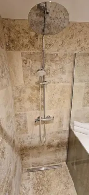 a shower with a shower head in a bathroom at Bel & ancien appartement T3 rénové dans Sartène in Sartène