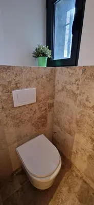 a bathroom with a toilet and a window and a plant at Bel & ancien appartement T3 rénové dans Sartène in Sartène