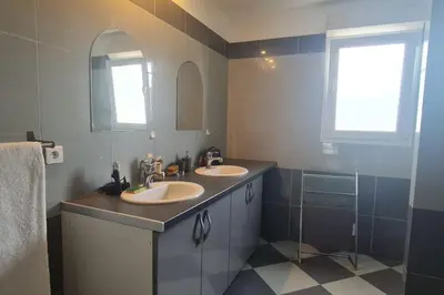 a bathroom with two sinks and a mirror at Magnifique villa avec piscine en bord de Mer in Lucciana