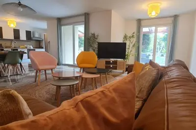 a living room with a couch and chairs and a tv at Magnifique villa avec piscine en bord de Mer in Lucciana
