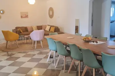 a living room with a wooden table and chairs at Magnifique villa avec piscine en bord de Mer in Lucciana