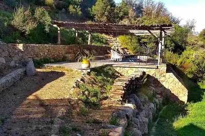 a patio with a stone bridge and a stone wall at Villa Falcone marinu ***** in Kamiesch