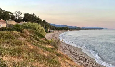 a view of a beach with a house and the ocean at Casa in Cervione