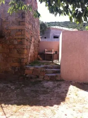 a brick building with a table in front of it at Appartement dans maison de village in Piana