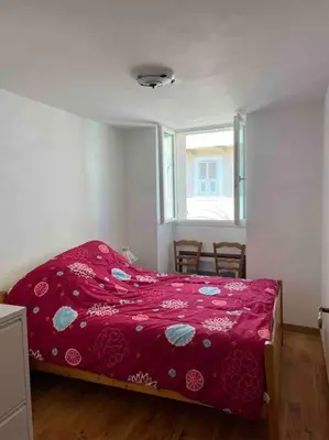 a bedroom with a red bed and a window at Appartement dans maison de village in Piana