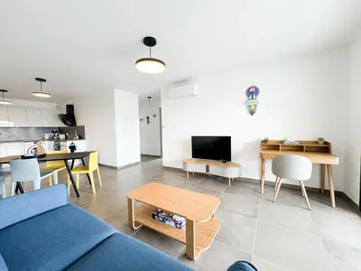 a living room with a blue couch and a table at BEL' ORIZONTE proche centre ville et plage in Propriano