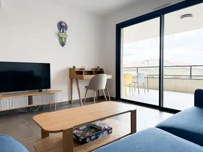 a living room with a tv and a table at BEL' ORIZONTE proche centre ville et plage in Propriano