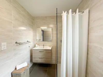 a bathroom with a shower curtain and a sink at BEL' ORIZONTE proche centre ville et plage in Propriano